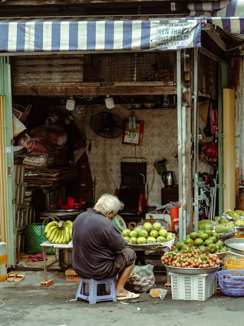Man Selling Groceries in a Street Market Stall 