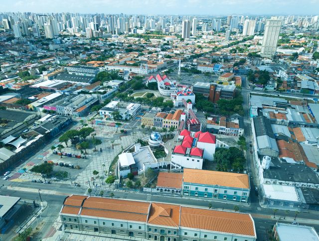 High-angle view of Fortaleza's urban landscape with architectural landmarks and red rooftops.