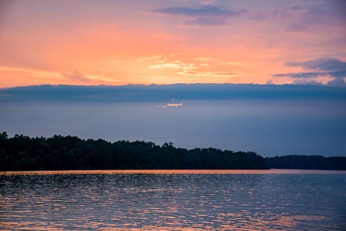 Clouds Gathering above Lake Shore at Sunset