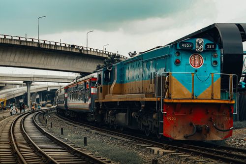 Free A vivid train travels beneath an overpass in Dhaka, Bangladesh. Stock Photo
