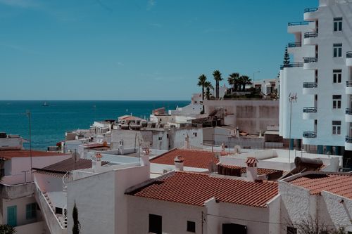 Free Charming Algarve townscape with ocean view, white buildings, and palm trees. Stock Photo