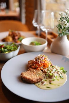 A beautifully plated vegetarian meal with fresh sprouts and creamy sauce in a stylish restaurant setting.
