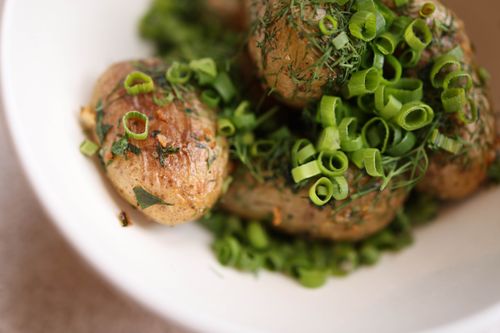 Free Close-up of roasted potatoes garnished with fresh dill and scallions, perfect for a gourmet meal. Stock Photo