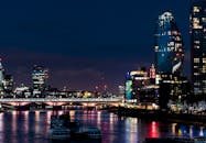 泰晤士河映衬着现代摩天大楼与桥梁，构成了伦敦夜间令人惊叹的城市景观