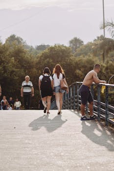 白天，一群成年人在城市公园的桥上散步、放松