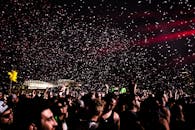 充满活力的夜间音乐会现场，人群欢腾，五彩纸屑飞舞，营造出令人兴奋的氛围