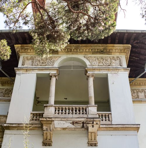 Free Elegant Ottoman-style balcony with intricate stonework, framed by trees, in a historic setting. Stock Photo