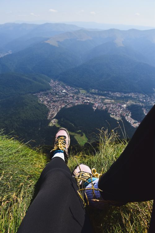 Free A hiker rests on a mountain ledge, overlooking a scenic valley view. Stock Photo