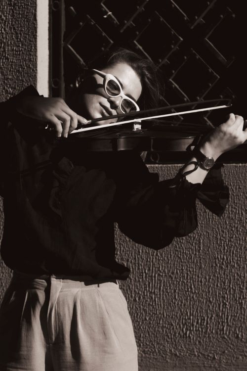 Free A woman violinist plays passionately in an artistic black and white portrait. Stock Photo