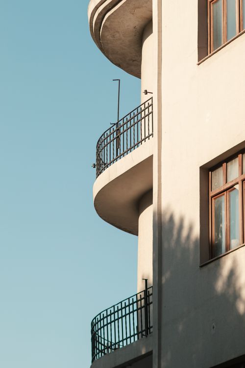 Free Vertical shot of a modern residential building facade featuring balconies against a clear sky. Stock Photo
