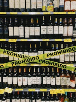 Wine bottles on shelves with prohibition tape in a store setting.