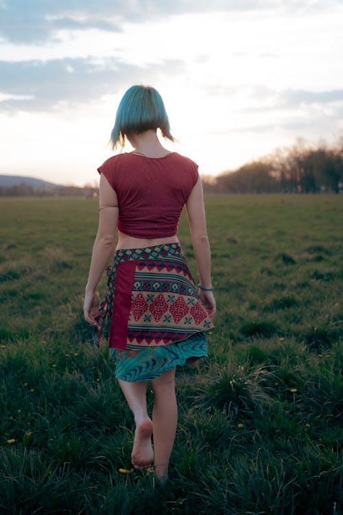 Woman in Ethnic Skirt Walking on Meadow
