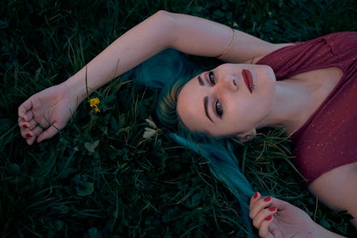 Woman in Dyed Hair Lying on Meadow