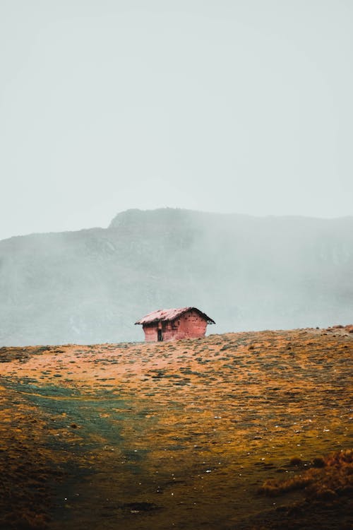 Vie of an Old Hut on a Hill in Fog 