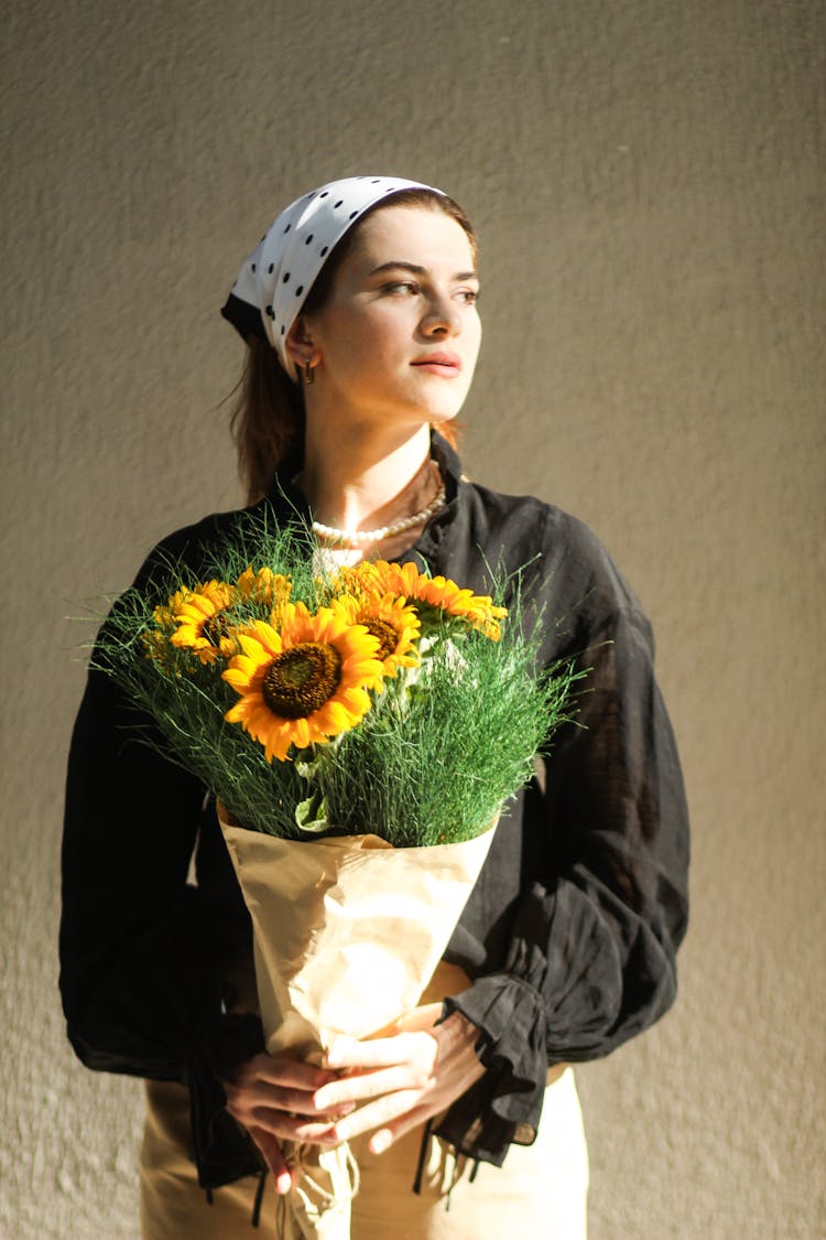 Young Woman In Black Blouse And Headscarf Posing With Sunflower Bouquet