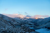 日出时分，雪山的壮丽景色、蜿蜒的道路和清澈的蓝天交相辉映