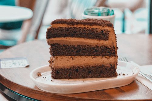 Free A close-up shot of a chocolate layer cake slice on a plate indoors. Stock Photo