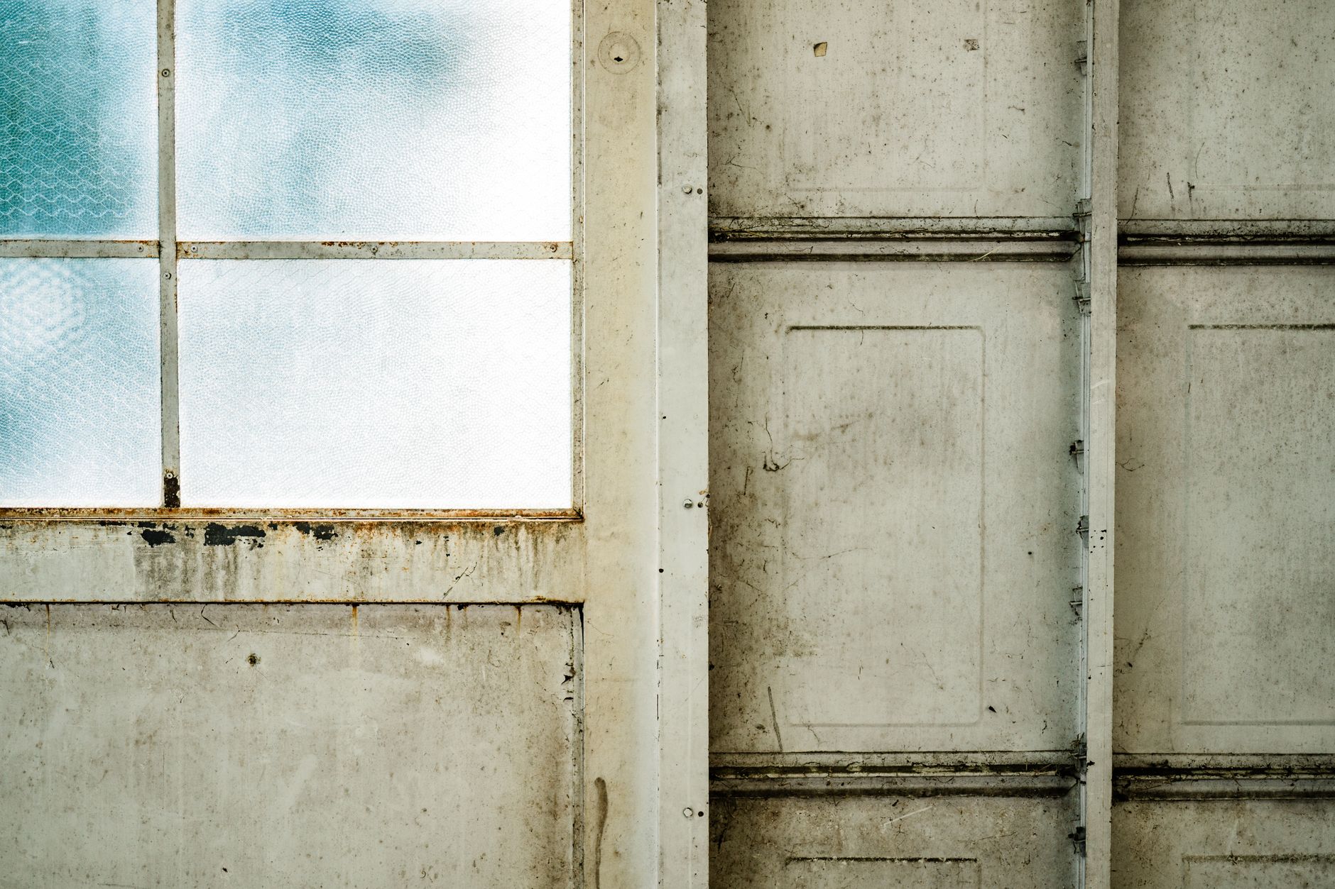A textured, weathered window and door showcasing an artistic rustic appeal.