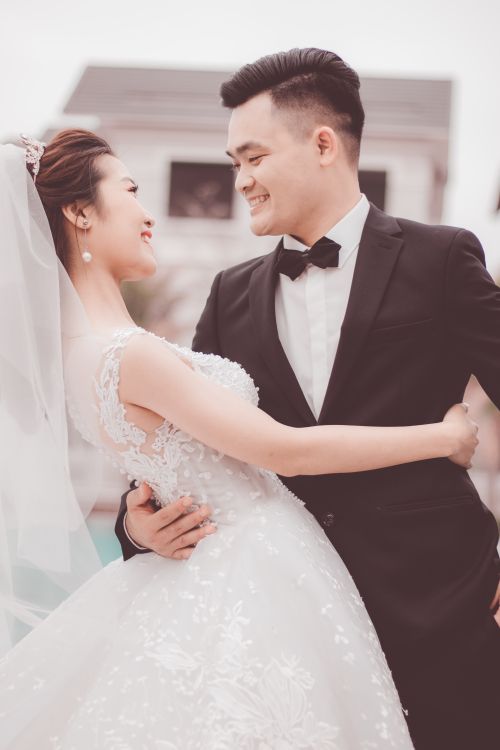 Free A happy bride and groom embracing outdoors in elegant attire, celebrating their love. Stock Photo