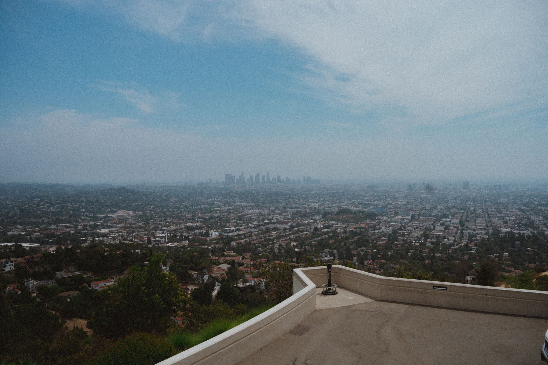 Beautiful panoramic view of Los Angeles cityscape from Griffith Observatory under a clear blue sky.