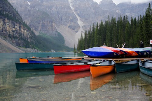 Canoes Moored on Lakeshore in Mountains