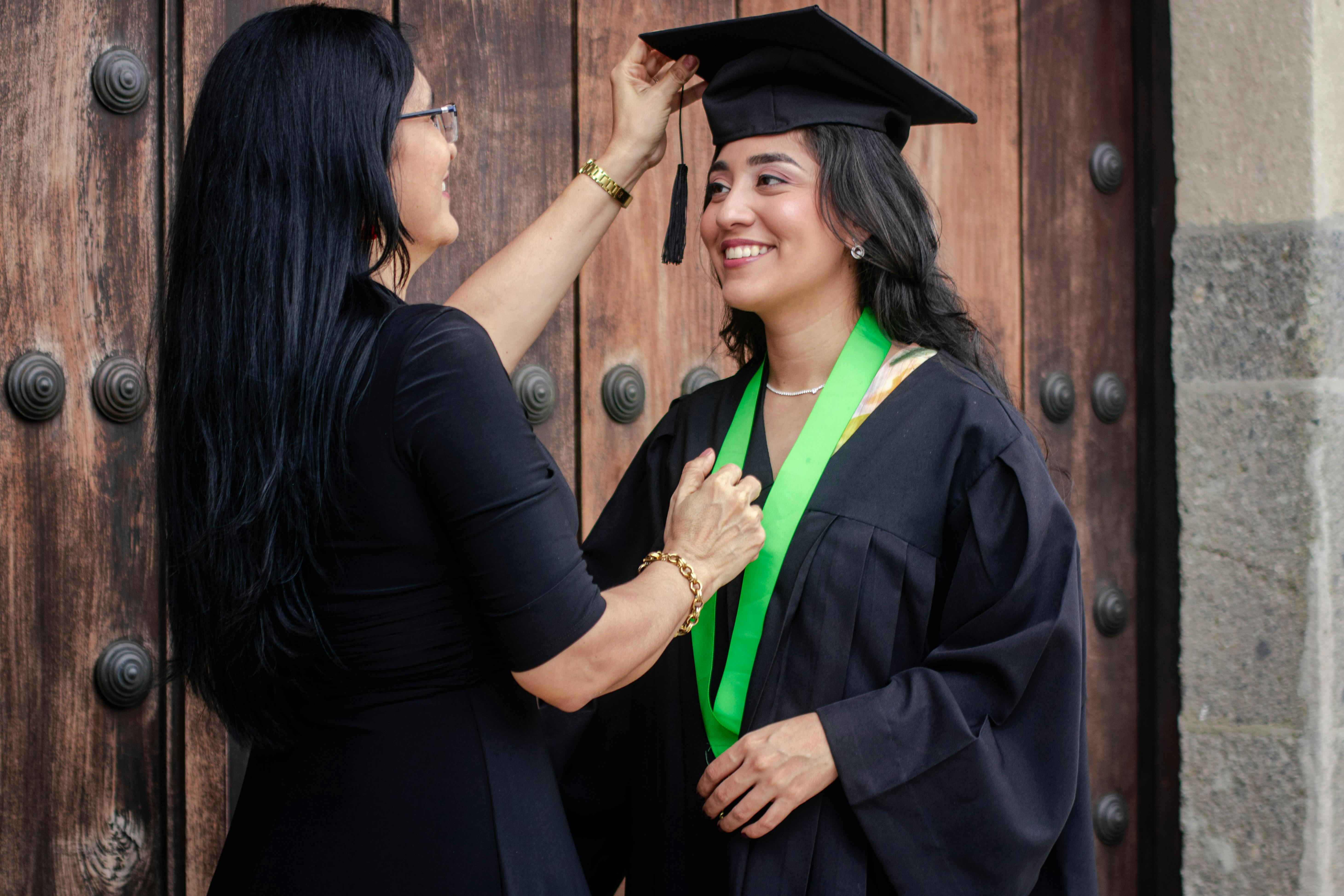 woman fixing the mortarboard on her daughters head