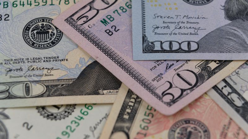 Detailed view of US currency, including $50 and $100 bills, symbolizing finance and economy.