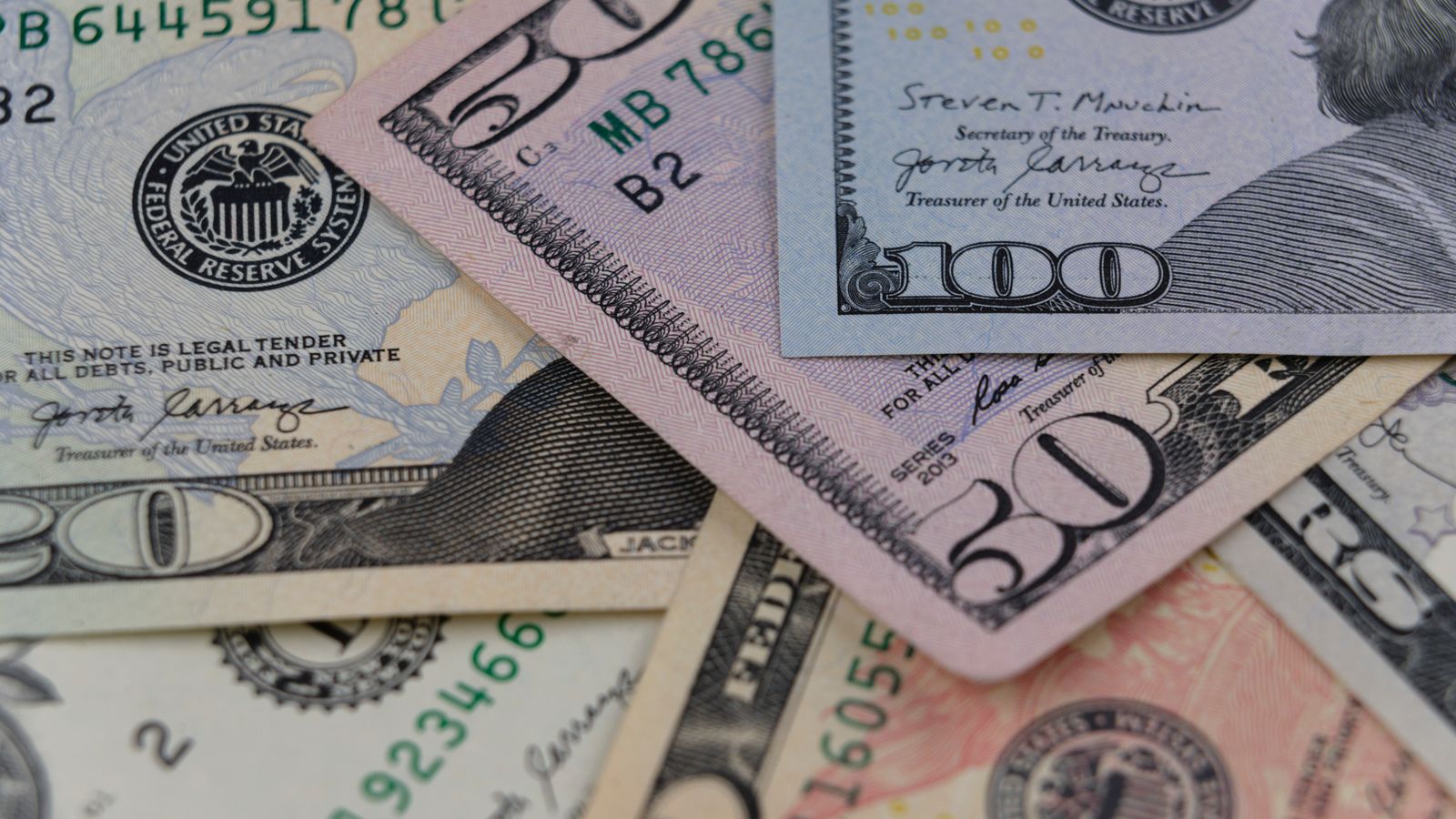 Detailed view of US currency, including $50 and $100 bills, symbolizing finance and economy.