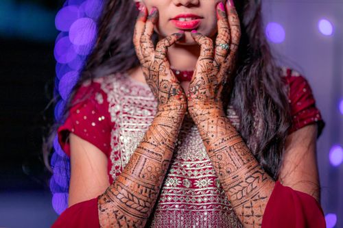 Free Close-up of intricate henna designs on a bride's hands wearing a traditional wedding dress in Malegaon, India. Stock Photo