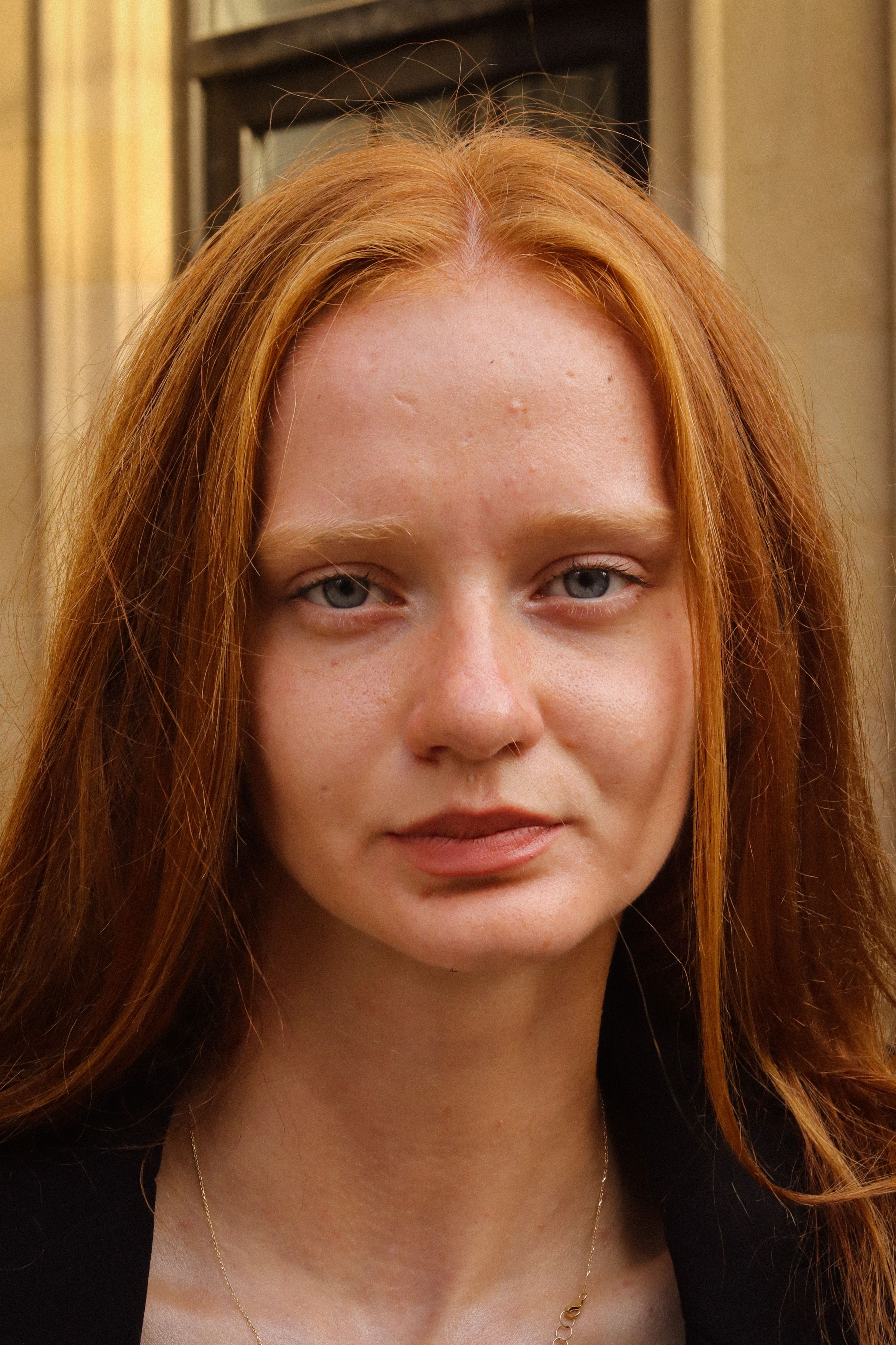 Close-up portrait of a young redhead woman with freckles, natural beauty outdoors.