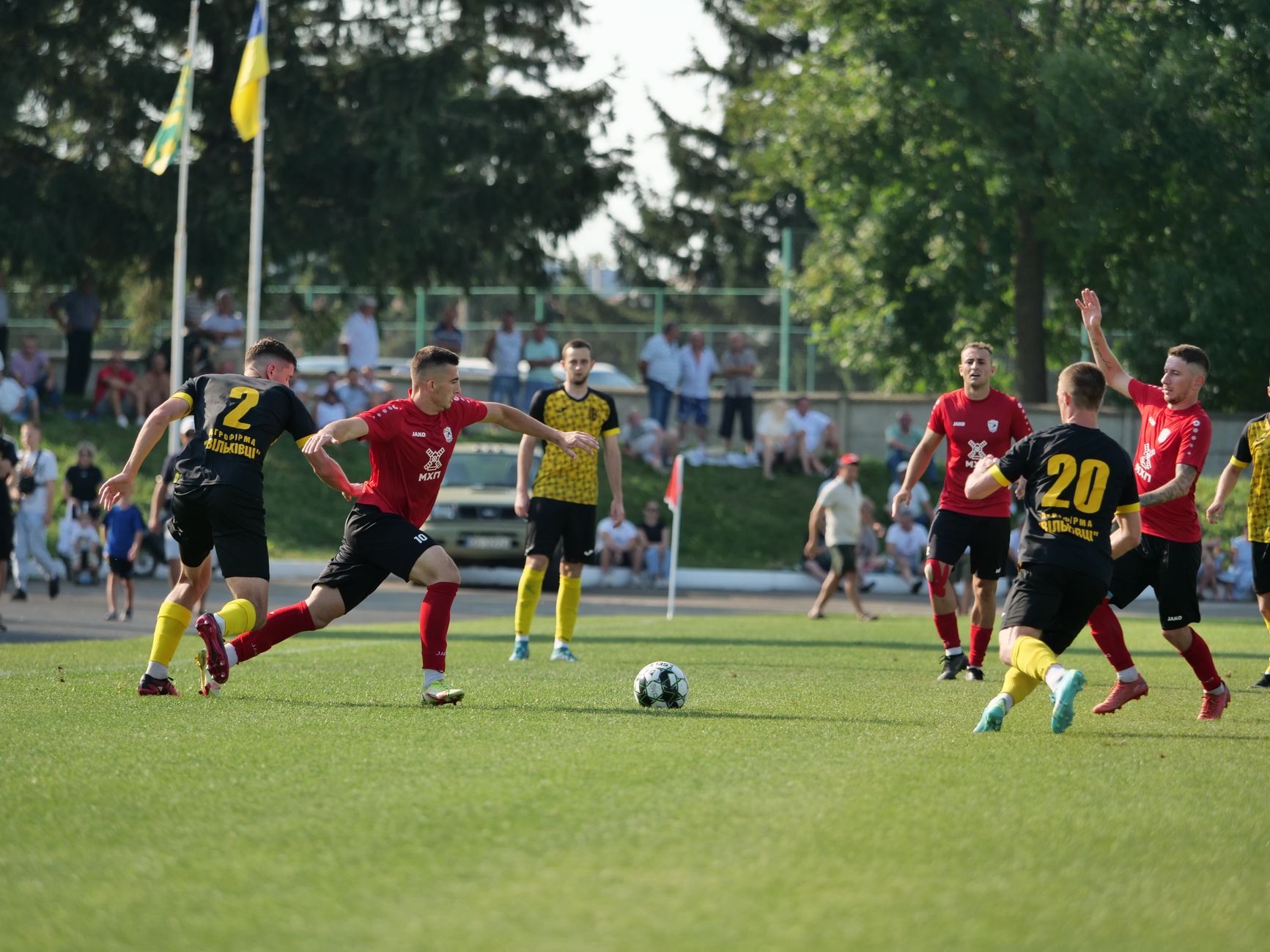 Floodlit football stadium showing defenders organizing a tense corner kick inside the penalty area