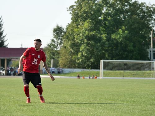 Free A soccer player in a red uniform on a sunny day, ready to make a move on the field. Stock Photo