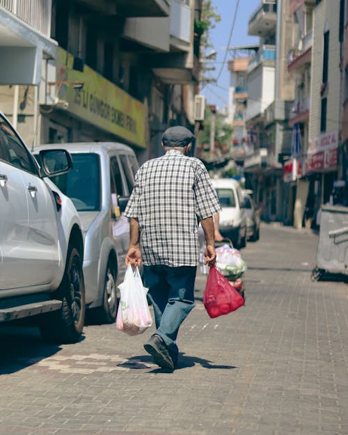 Man Walking with Shopping Bags on Street