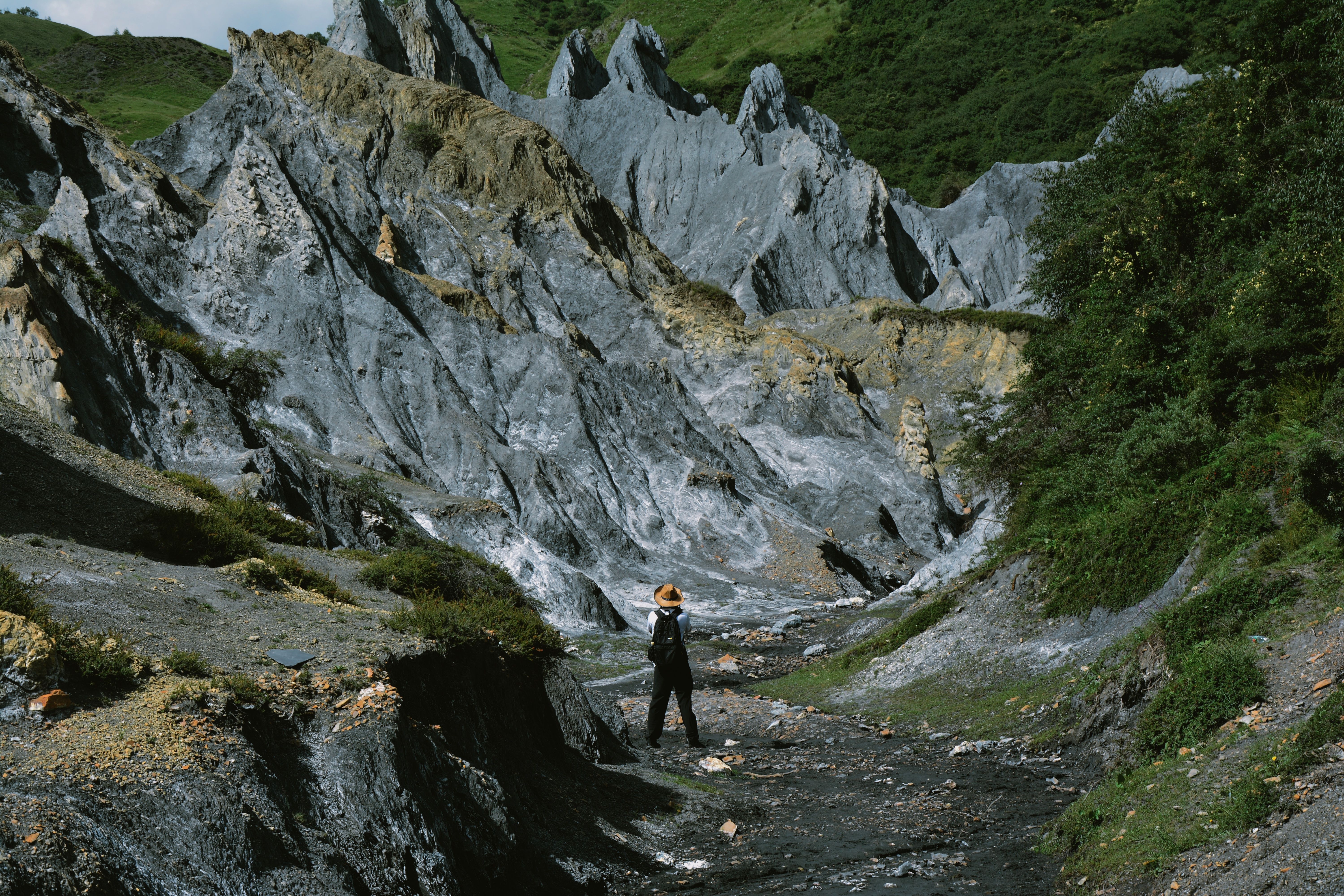 Person in Hat Hiking among Rocks · Free Stock Photo