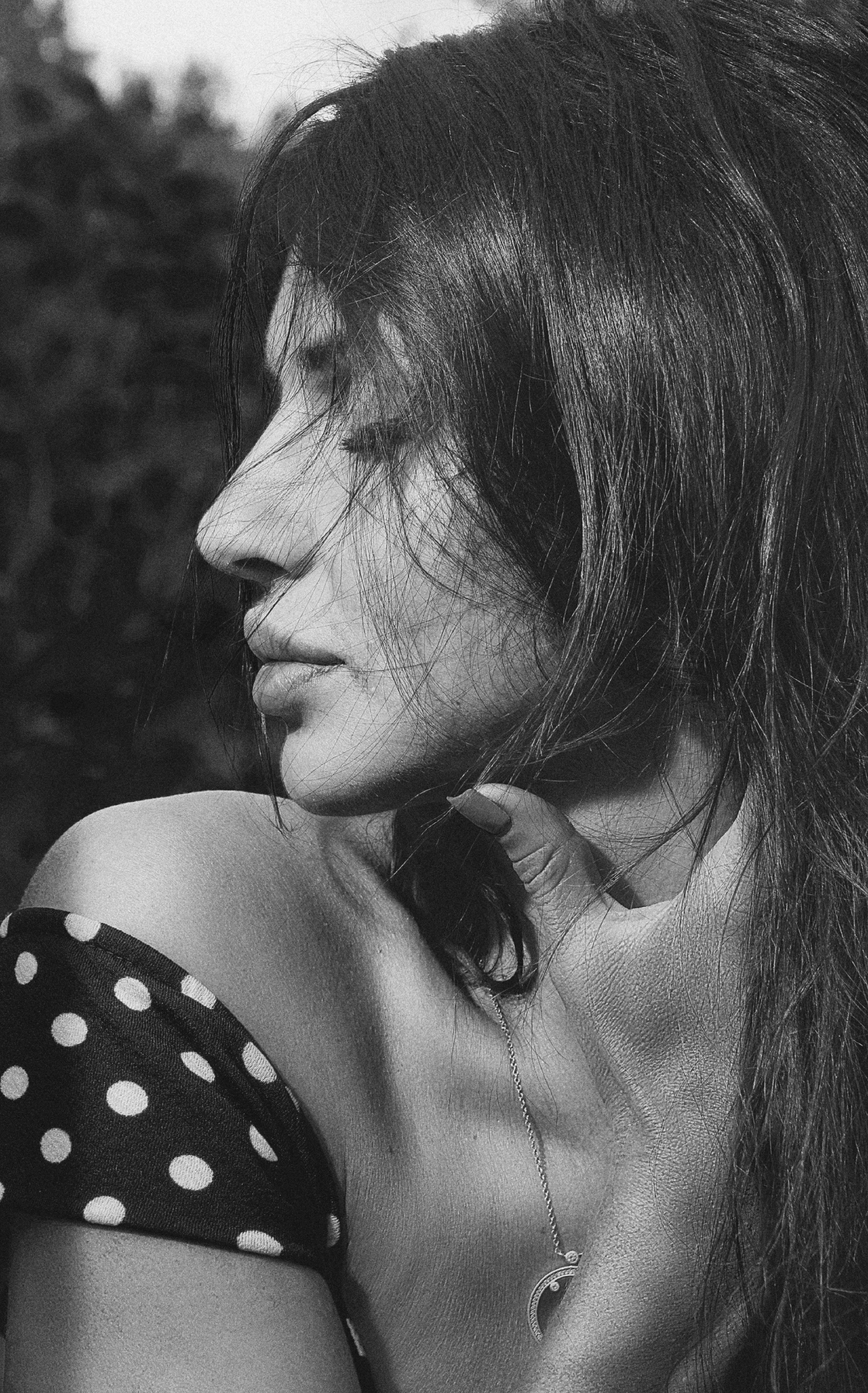 Elegant black and white profile portrait of a woman in a spotted dress.