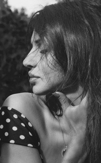 Elegant black and white profile portrait of a woman in a spotted dress.