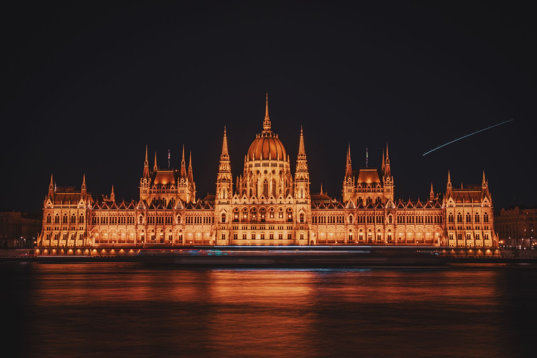 A stunning night view of the Hungarian Parliament building, beautifully illuminated against the night sky.