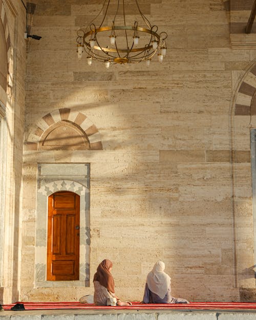 Women Sitting on the Floor by a Wooden Door