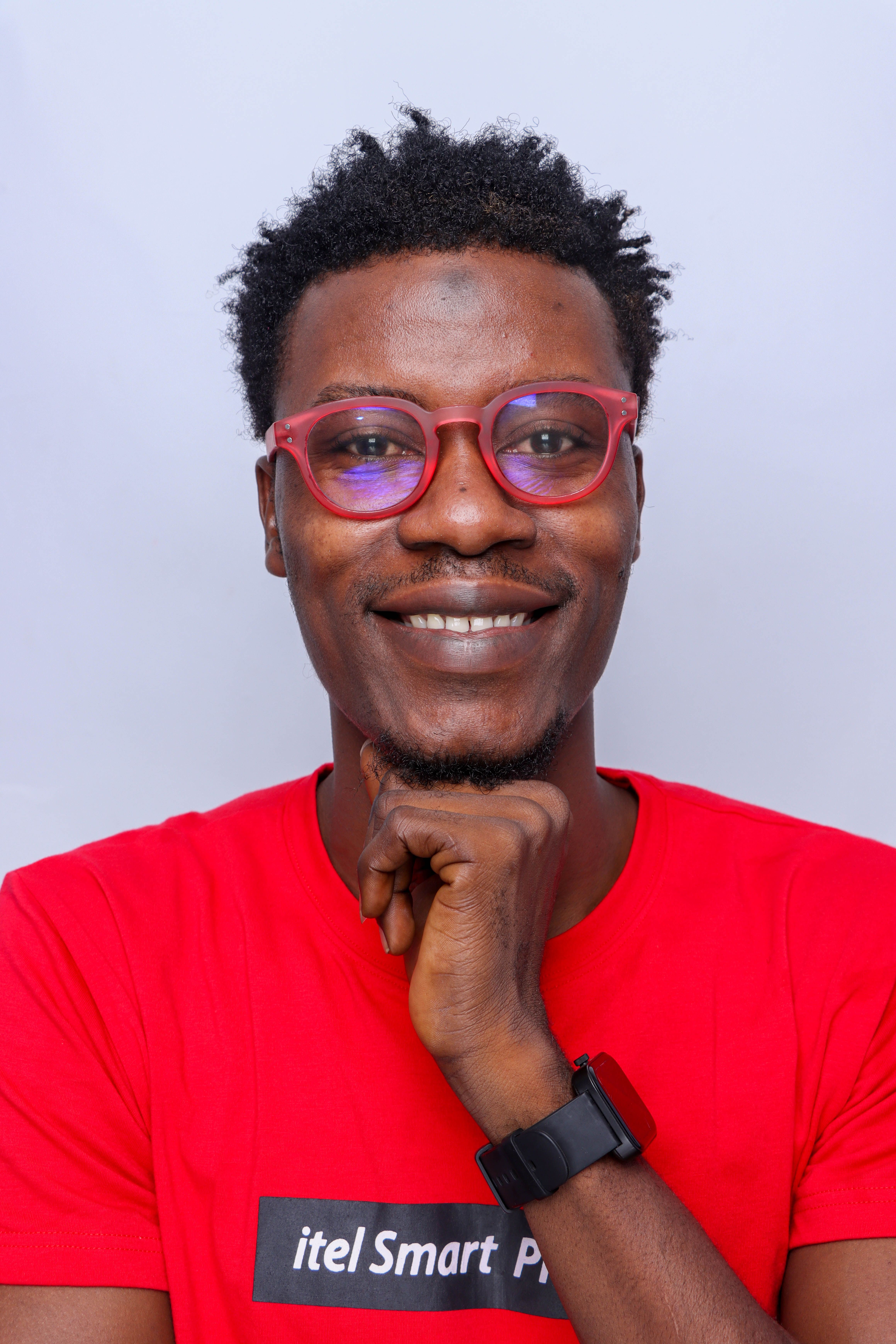 Portrait of a cheerful man wearing red glasses and a watch, exhibiting a casual style.
