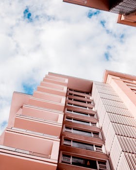 现代化的高层建筑与时尚的设计元素，在明亮的蓝天与白云映衬下显得格外醒目