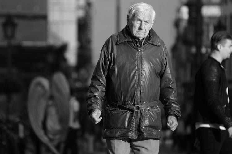 Senior Man Walking On A Street In Old Jacket