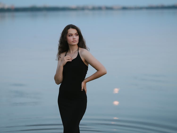 Beautiful Woman In Black Dress Posing On Lakeshore