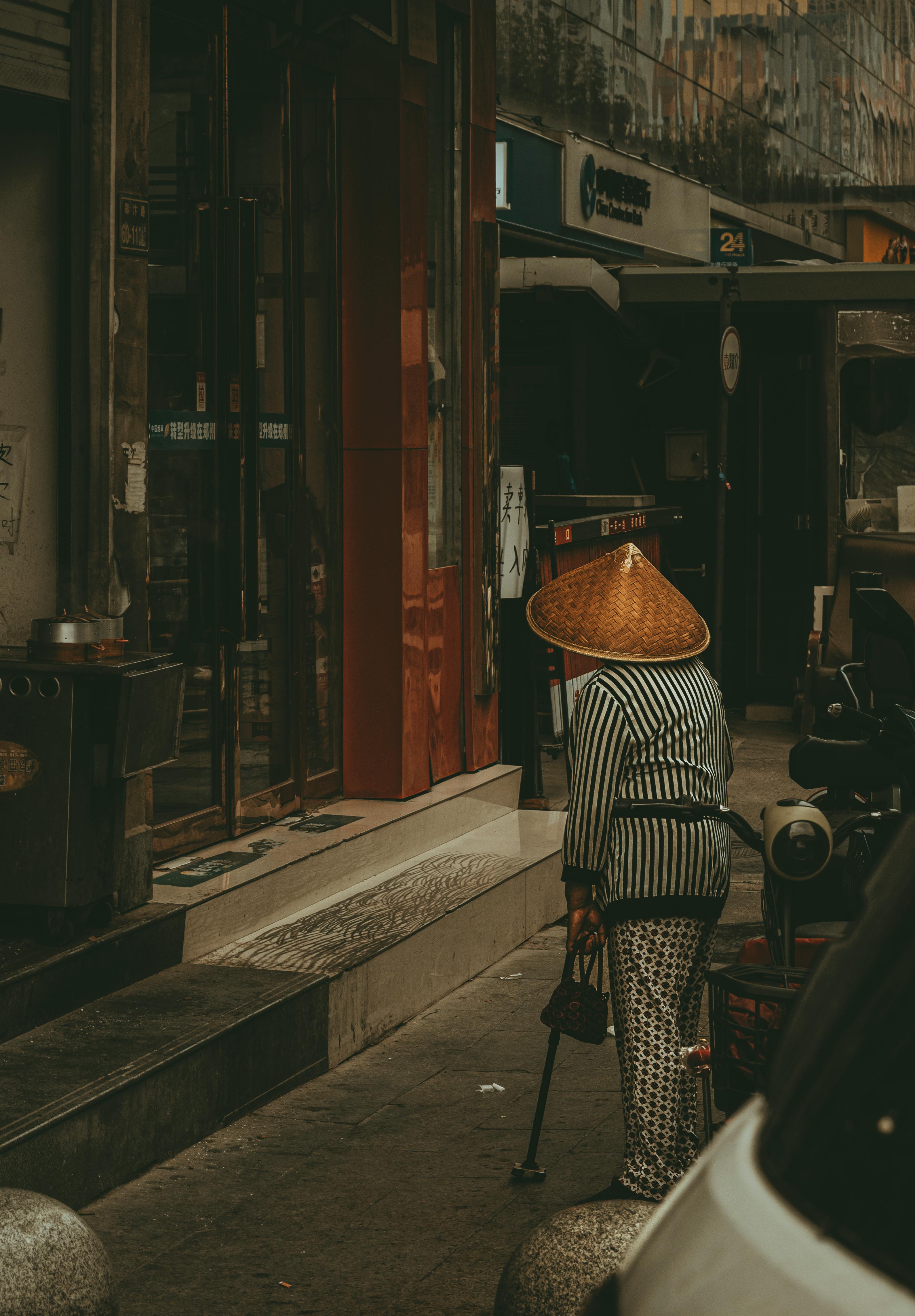 woman in traditional conical hat on city street