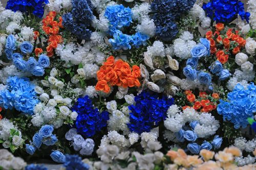 Free A vivid bouquet featuring diverse roses and hydrangeas in striking blue, white, and orange hues. Stock Photo