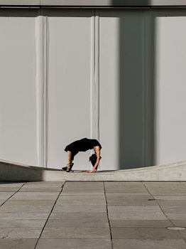 Woman performing exercise on architectural structure in Berlin.