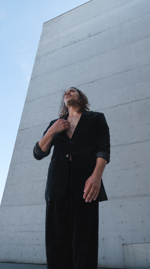 Free Man in a fashionable outfit poses against a modern architectural backdrop in Berlin. Stock Photo