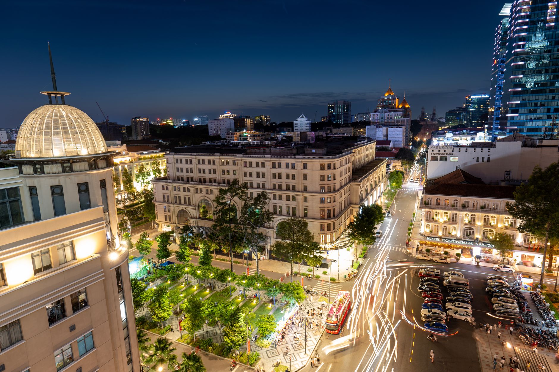 Vibrant night view of Ho Chi Minh City with bustling streets, iconic landmarks, and light trails.