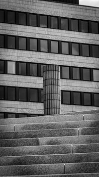 Black and white photo of urban architecture featuring geometric patterns and a column.