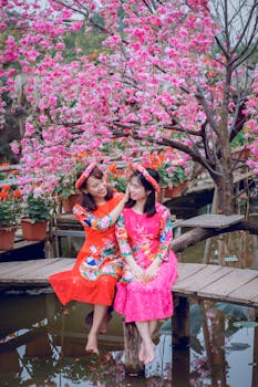 两名身着传统服装的女子在生机勃勃的花园中合影