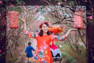 春节期间，亚洲妇女身穿传统服装，在户外举着灯笼庆祝